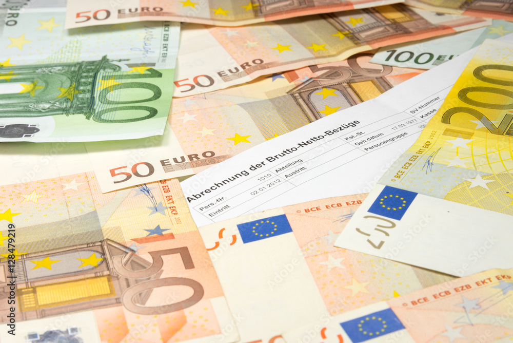Eine Gehaltsabrechnung und viele Euro Geldscheine Eine Gehaltsabrechnung und viele Euro Geldscheine