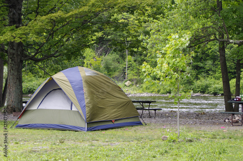 Green camping tent beside river