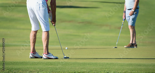 Playing golf preparing to shot,senior putting on green