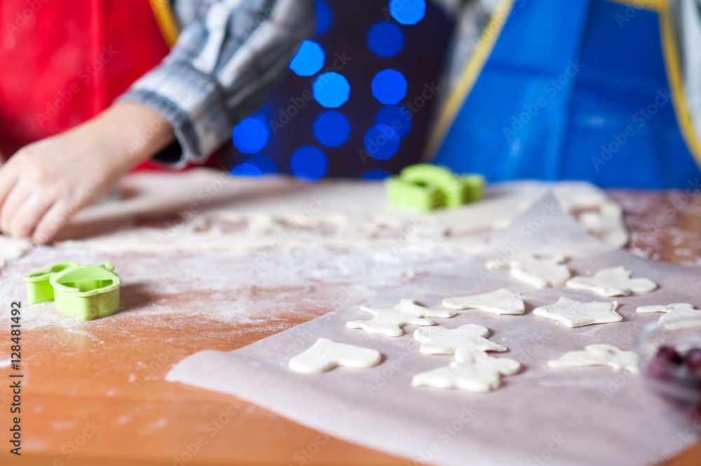 Fototapeta premium hands of a child who is preparing cookies in the kitchen with flour and dough