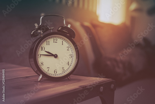 modern black alarm clock on wooden table side