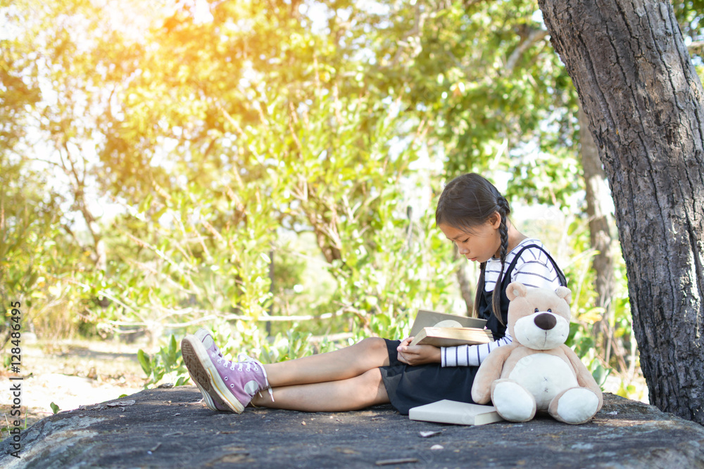 Asian girl reading a book on the park in free time. Soft focus Asian girl reading a book on the park in free time. Soft focus