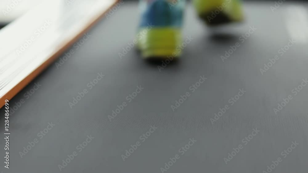 Woman in fitness center running on a treadmill. Leg close up. Woman in fitness center running on a treadmill. Leg close up.