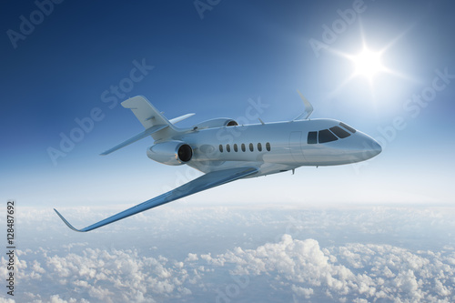 Private jet  flying above the clouds with the sun in blue sky