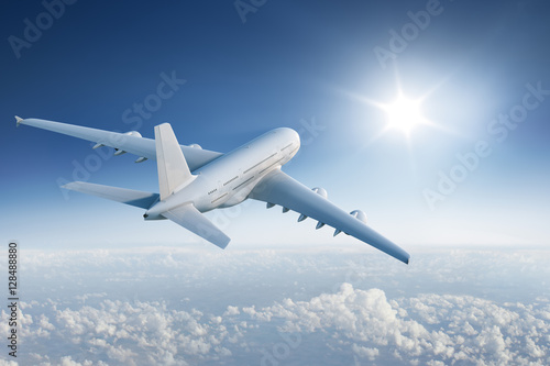 Fototapeta Big plane flying towards with the sun in blue sky