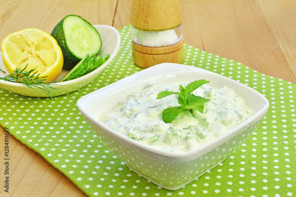 Tzatziki sauce. Greek cucumber yogurt dip in white bowl over wooden table. Tzatziki sauce. Greek cucumber yogurt dip in white bowl over wooden table.