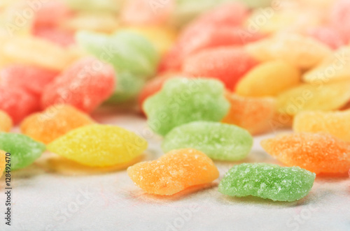 many multicolored candies on a pink background, low angle horizo