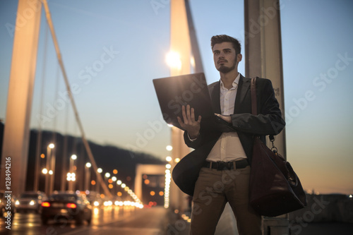 Businessman carrying his laptop photo