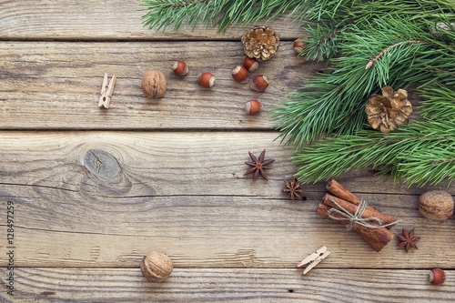 Christmas background with pine branches, nuts, cinnamon sticks a