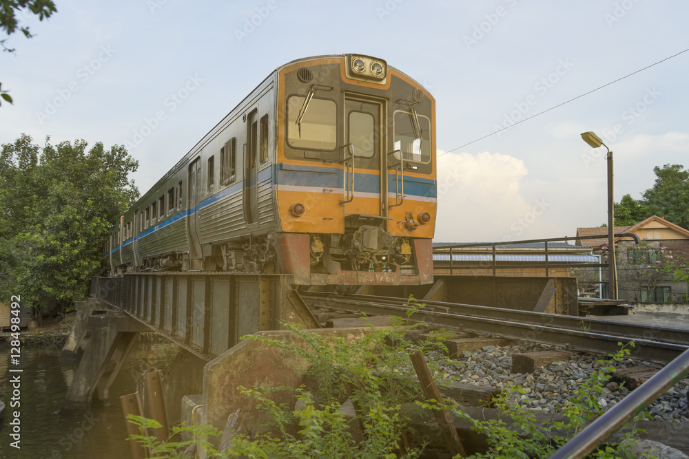 Naklejka premium old train on railway bridge arrived train station in Thailand sun light evening