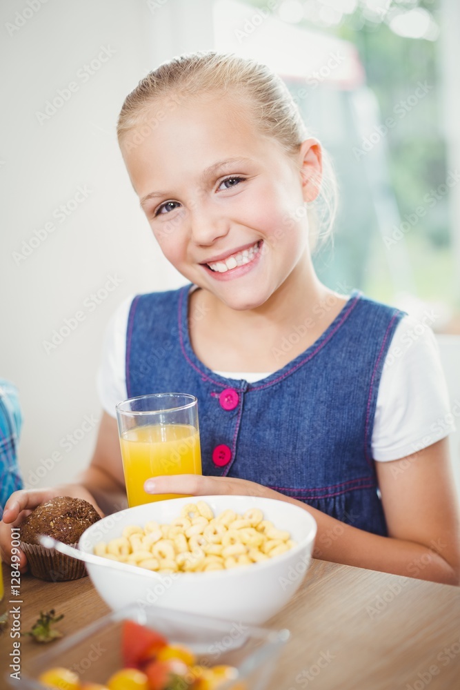 Happy girl having breakfast by table Happy girl having breakfast by table