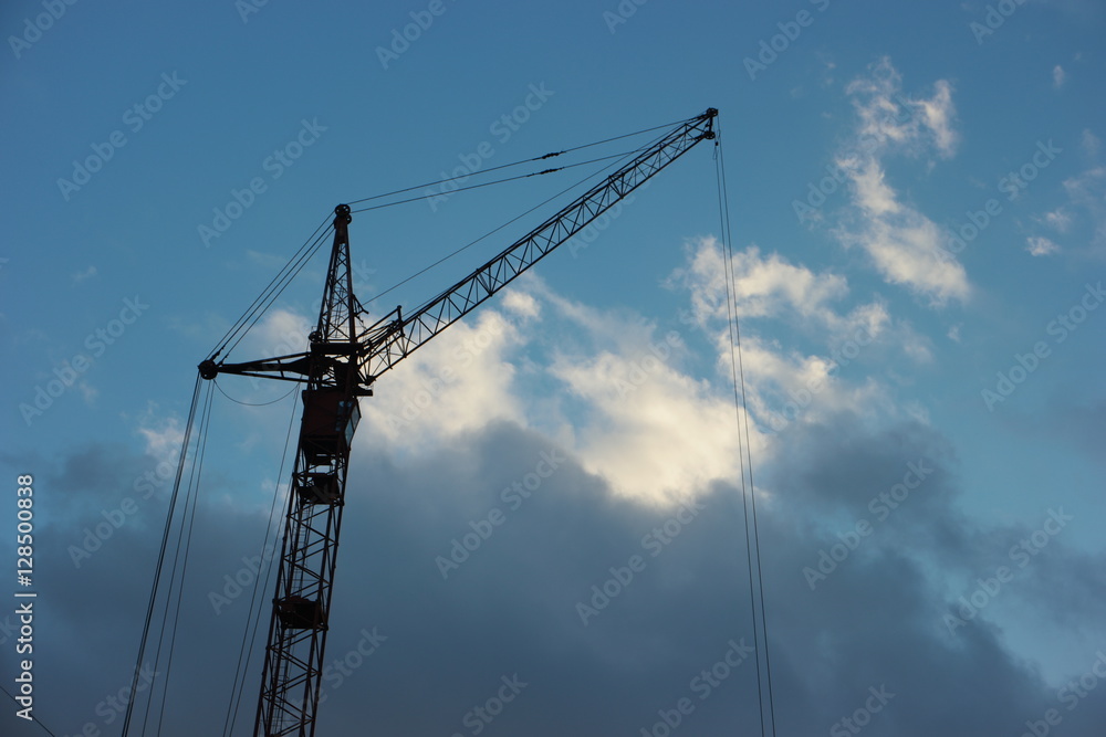 construction crane against cloudy blue sky