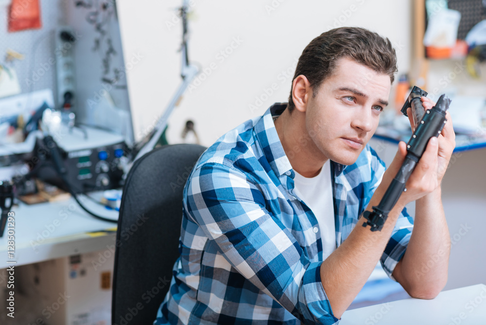 Concentrated man looking at drone detail Concentrated man looking at drone detail