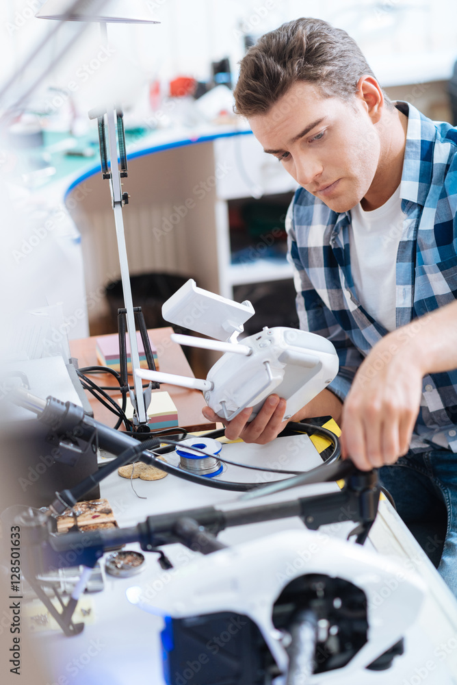 Concentrated man holding remote controller and drone Concentrated man holding remote controller and drone