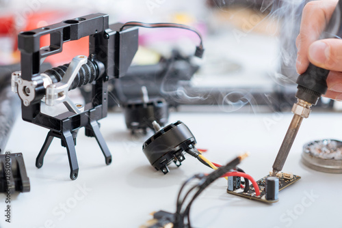Tableau sur toile Close up of mans hands soldering drone chip