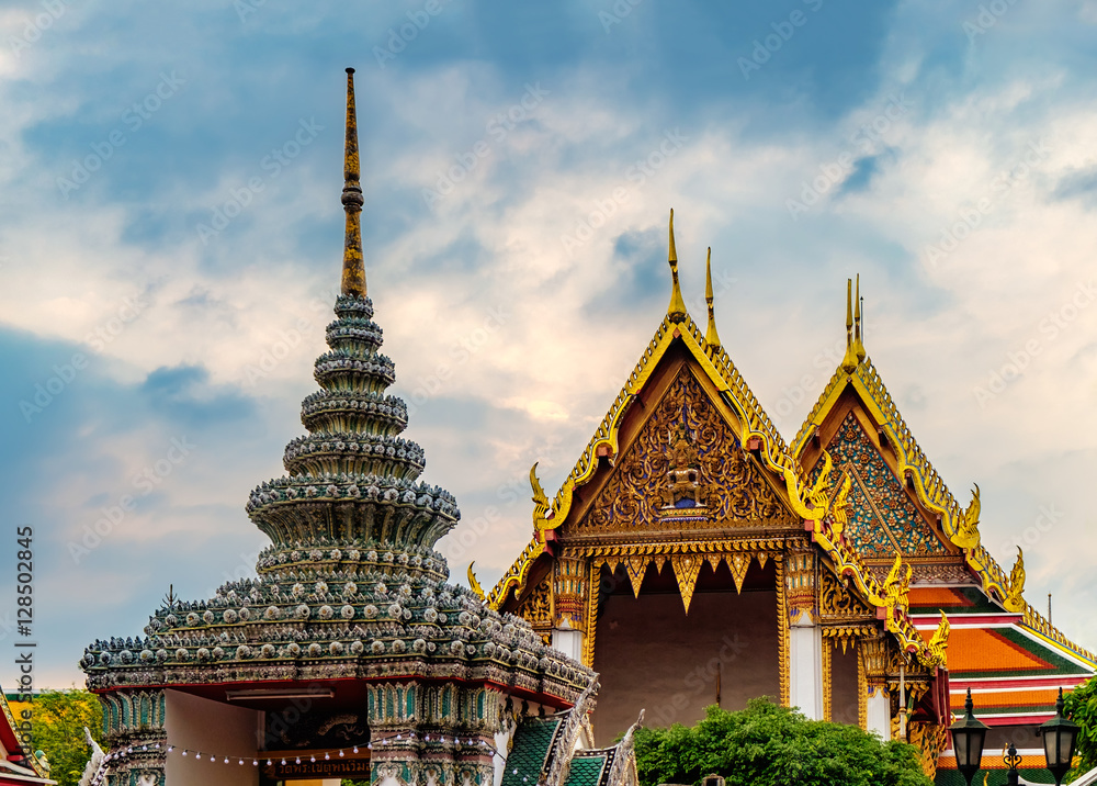 View of colorful rooftops of Temple of the Emerald Buddha or Wat Phra Kaew with cloudy sky, Bangkok, Thailand