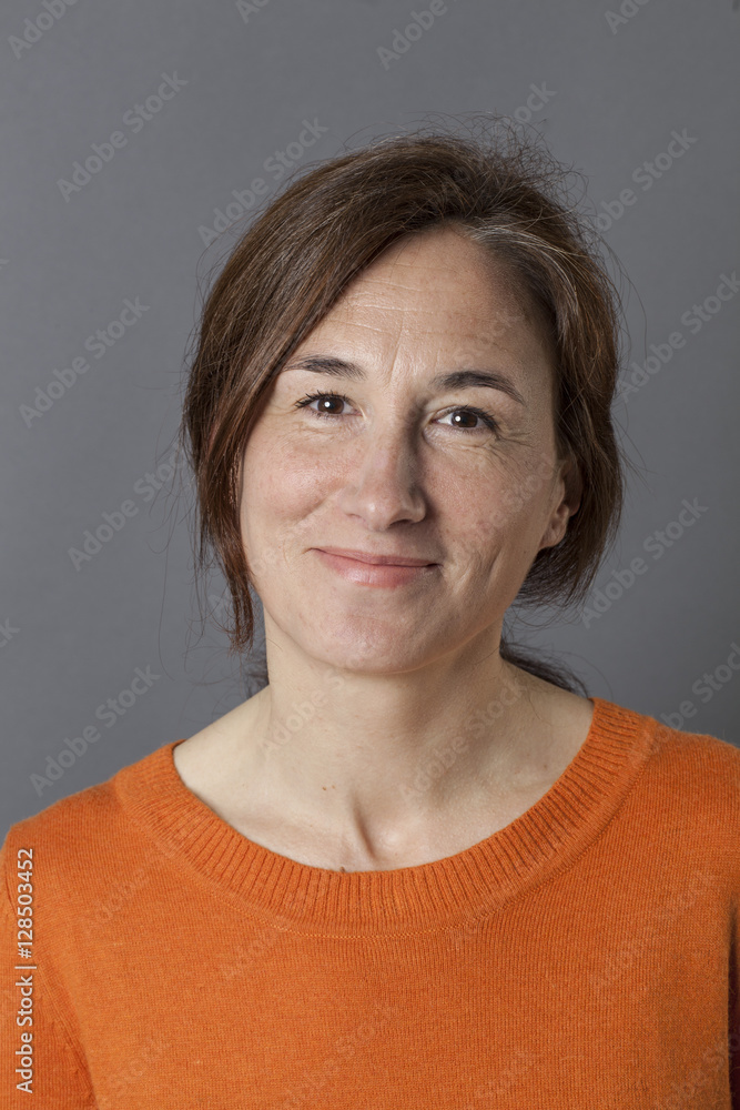 pretty middle aged woman with a natural smile, grey background pretty middle aged woman with a natural smile, grey background