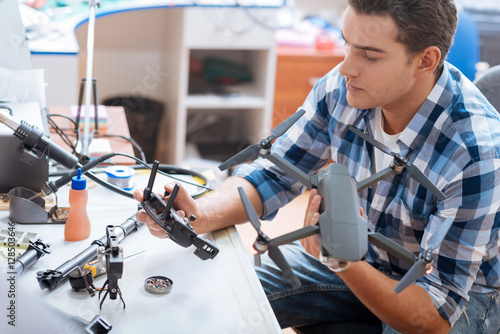 Photos Young man putting together drone propeller and other details