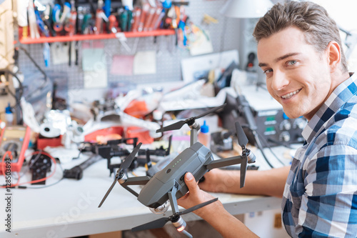 Joyful man holding drone propeller and remore controller