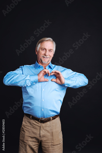 Old man holding hands in shape of heart