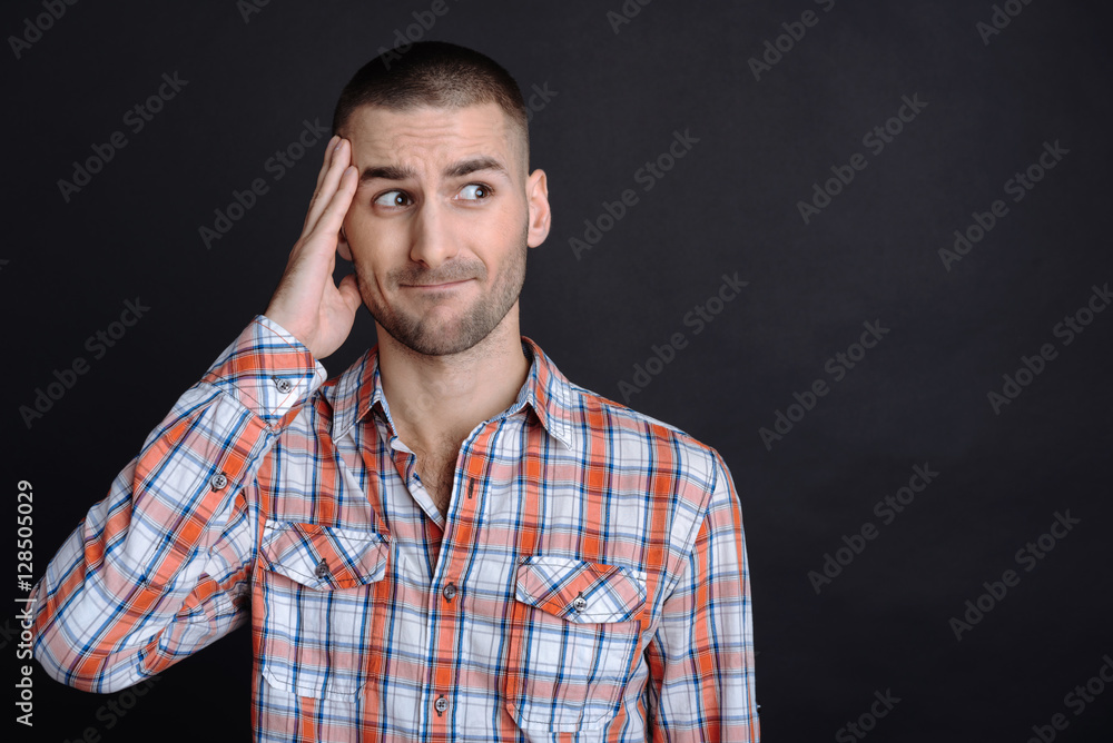 Young man wrinkling up his forehead Young man wrinkling up his forehead