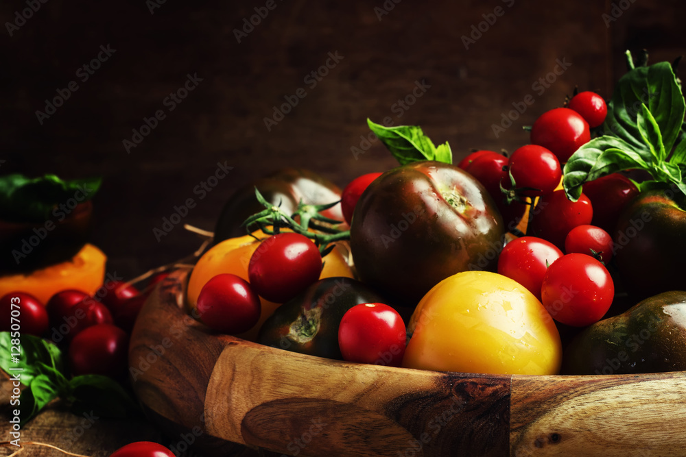 Various tomatoes on old wooden table, selective focus Various tomatoes on old wooden table, selective focus