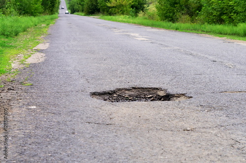 dangerous pothole in the asphalt highway, summer