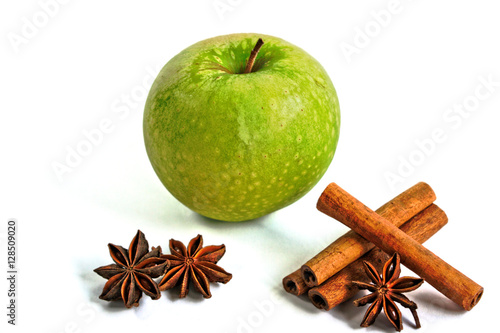 Green apple and cinnamon sticks with star anise on a white background