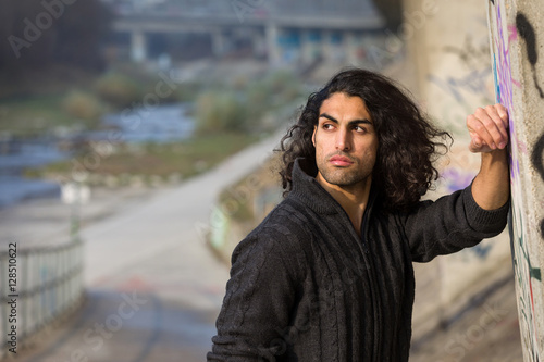 Muscular mediterranean man standing at a highway bridge