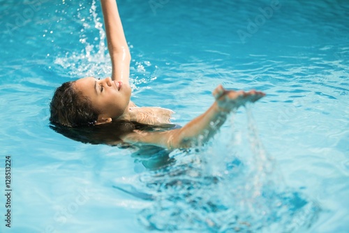 Beautiful woman splashing water in swimming pool
