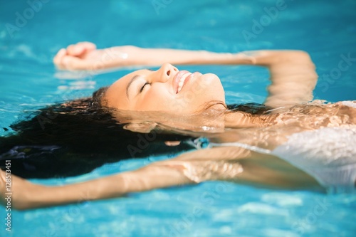Beautiful woman floating in pool