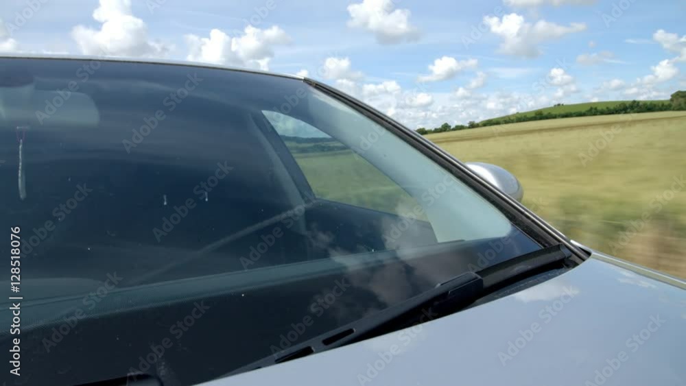 Exterior windscreen close up of car driving on country road Exterior windscreen close up of car driving on country road