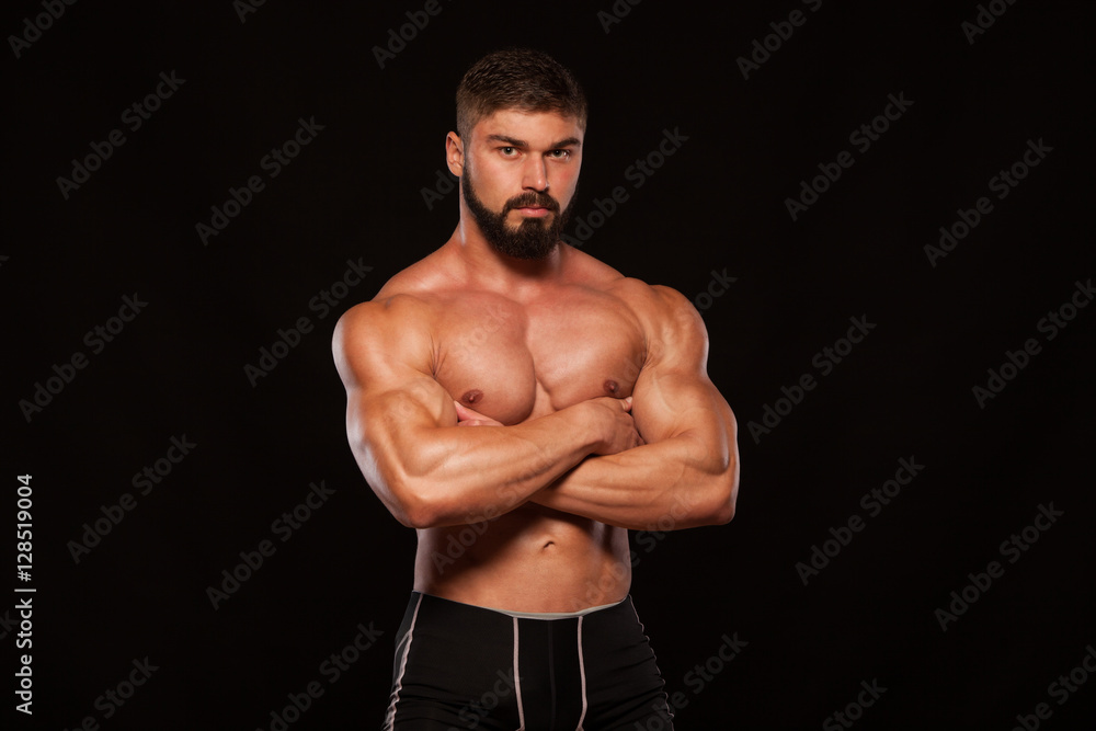 Strong Athletic Man Fitness Model Torso showing six pack abs. isolated on black background with copyspace