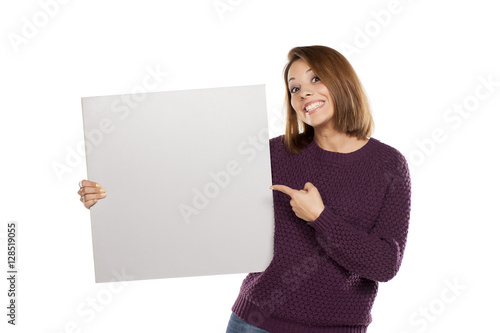 young beautiful woman in a purple sweater holding a blank board for advertising