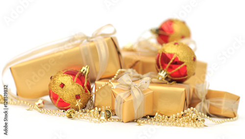 Golden gift boxes with golden ribbon and chrismas balls on white