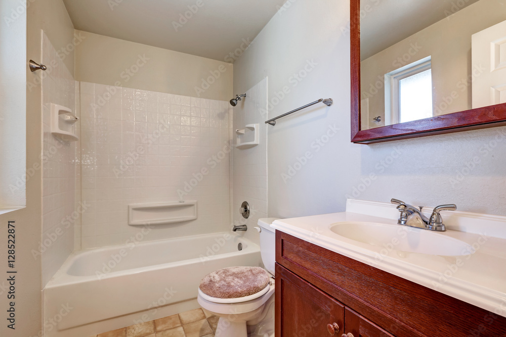White bathroom with mahogany vanity cabinet White bathroom with mahogany vanity cabinet