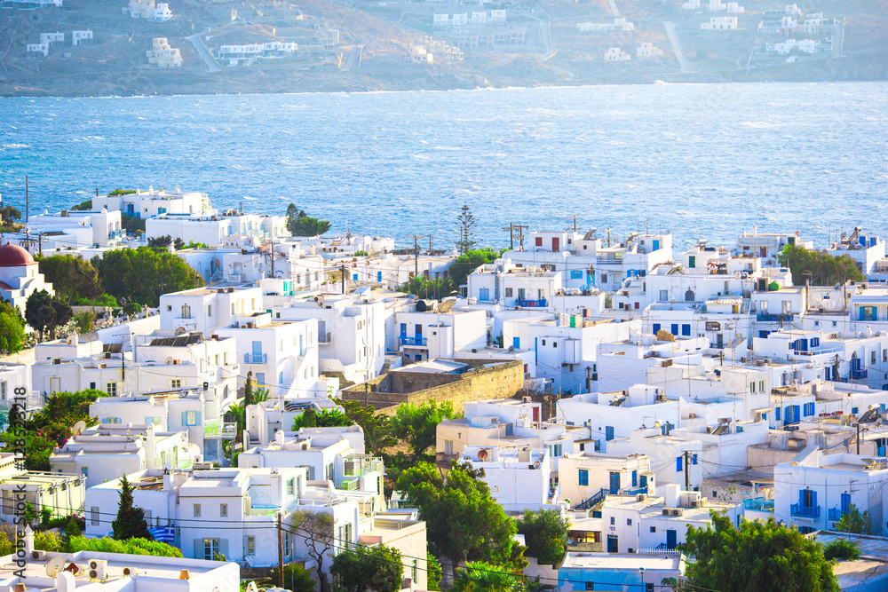Top view of the old city and the sea on the island of Mykonos, Greece. A lot of white houses against the blue sky