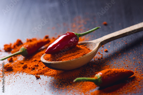 фотографія Red chilli peppers on a wooden, black table with spicy