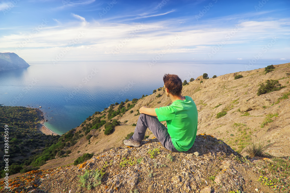 Traveler man sitting on top of mountain.