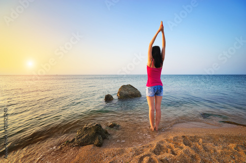 Slender woman girl on seashore deals morning gymnastics. Fitness on the beach. Fitness and gymnastic composition