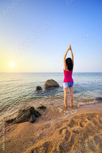 Slender woman girl on seashore deals morning gymnastics. Fitness on the beach. Fitness and gymnastic composition © silentgos