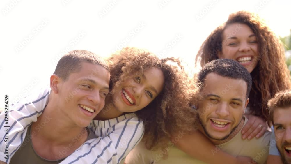 Close up of six young adult friends piggybacking outdoors Close up of six young adult friends piggybacking outdoors