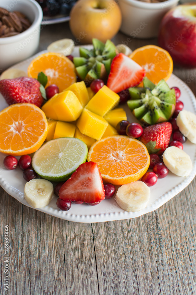 Vegan breakfast: variety of fruits, nuts and berries on the white wooden table, selective focus, copy space for text Vegan breakfast: variety of fruits, nuts and berries on the white wooden table, selective focus, copy space for text
