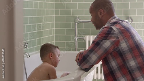 Father And Son Having Fun At Bath Time Together