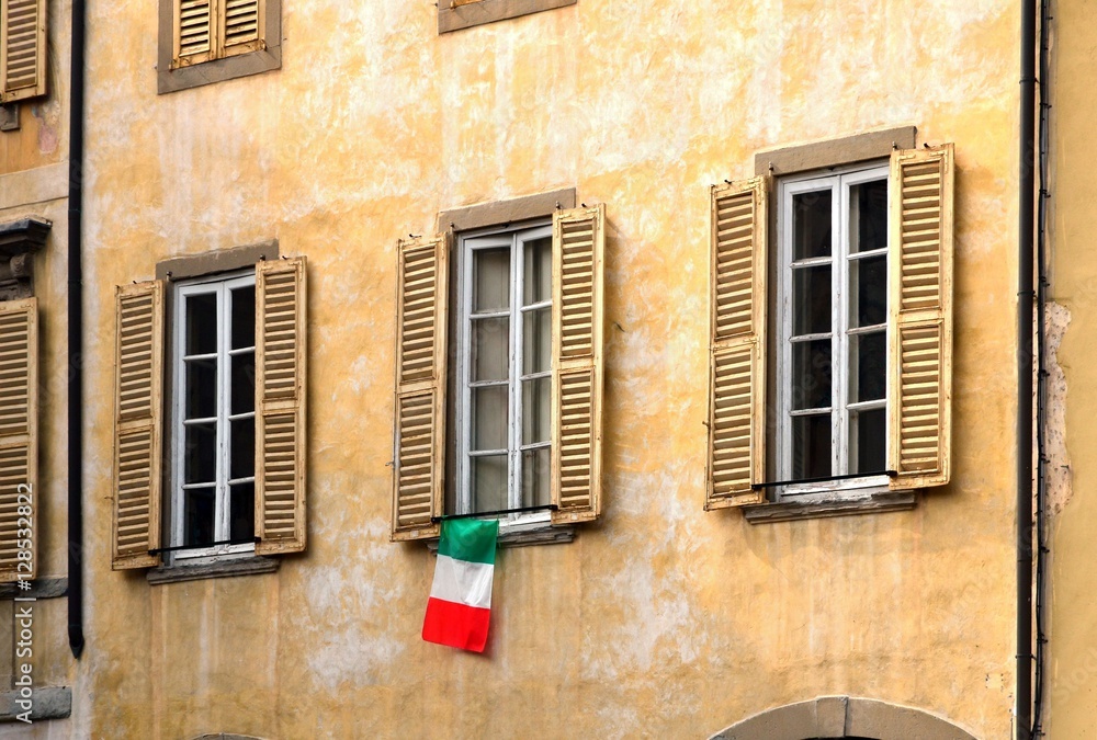 old window with flag in Bergamo Italy