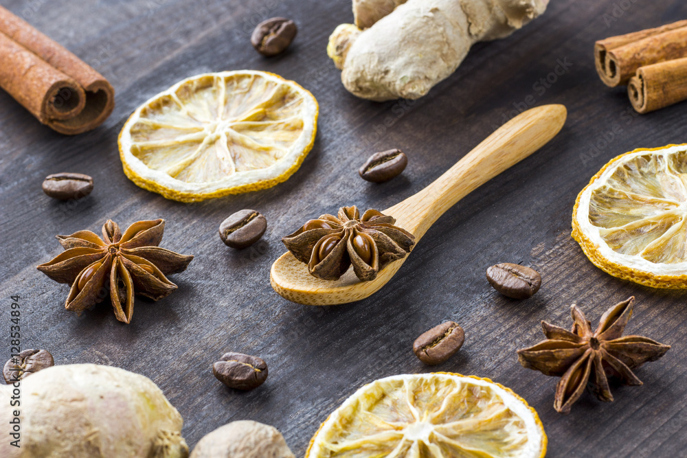 star anise, dried lemon, cinnamon and ginger with wooden spoon on wooden table star anise, dried lemon, cinnamon and ginger with wooden spoon on wooden table