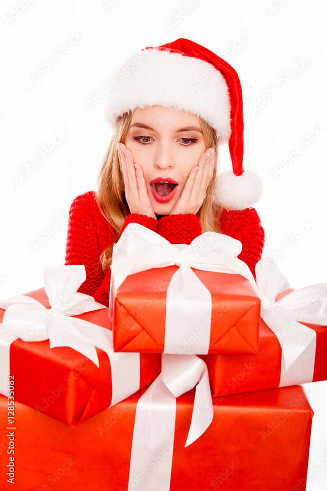 Portrait of surprised santa girl looking on many christmas gifts Portrait of surprised santa girl looking on many christmas gifts