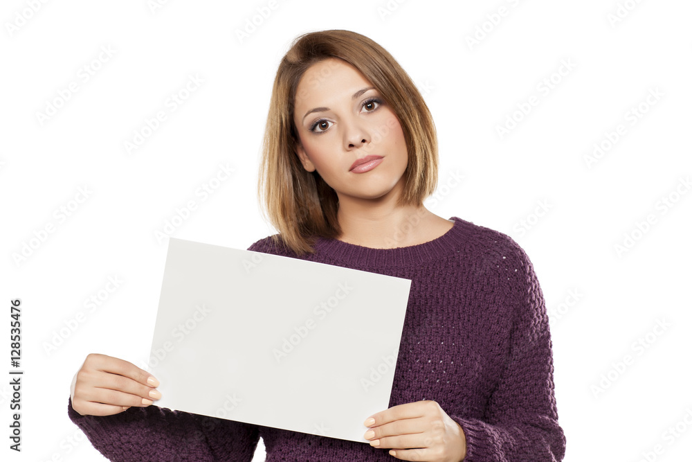 serious young beautiful woman holding a blank sheet of paper for advertising serious young beautiful woman holding a blank sheet of paper for advertising