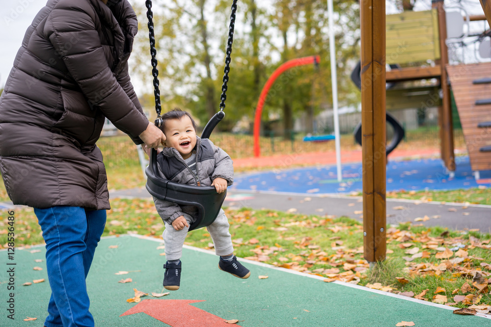 Obraz premium Baby and mother paly swing in the park