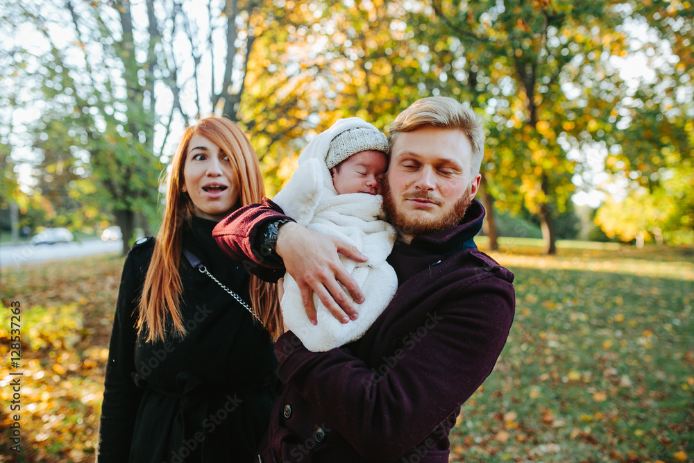 young family and newborn son in autumn park young family and newborn son in autumn park